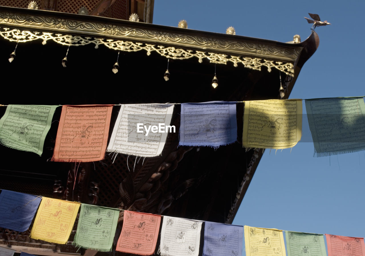 Low angle view of prayer flags against temple
