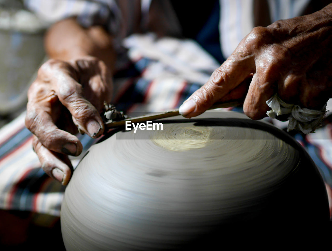 Midsection of man making pottery