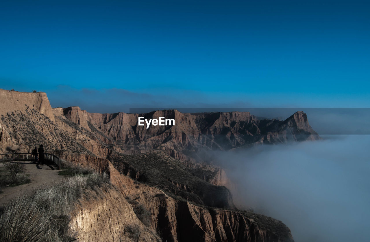 Scenic view of mountain against blue sky