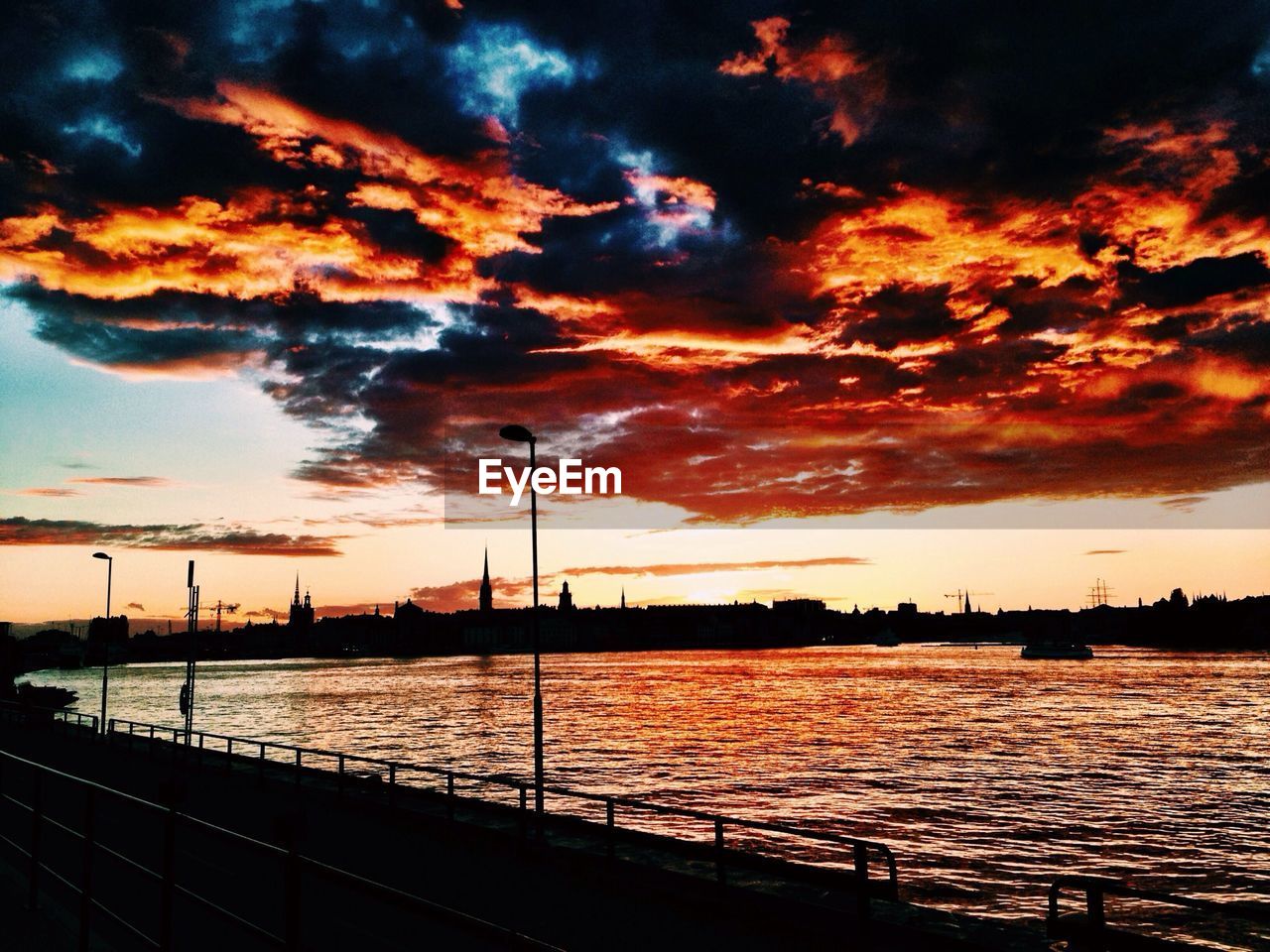 Scenic view of dramatic sky over river during sunset