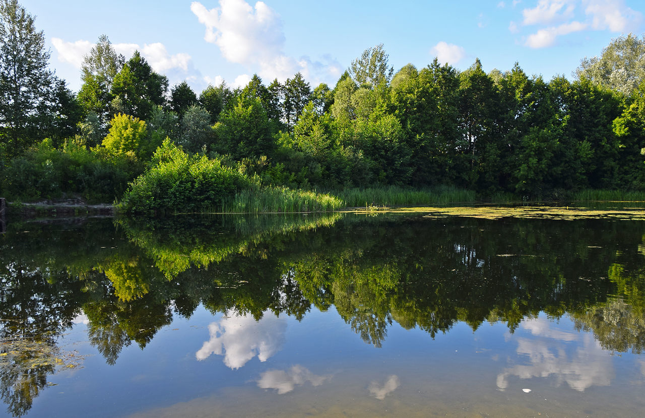 Scenic view of calm lake against cloudy sky