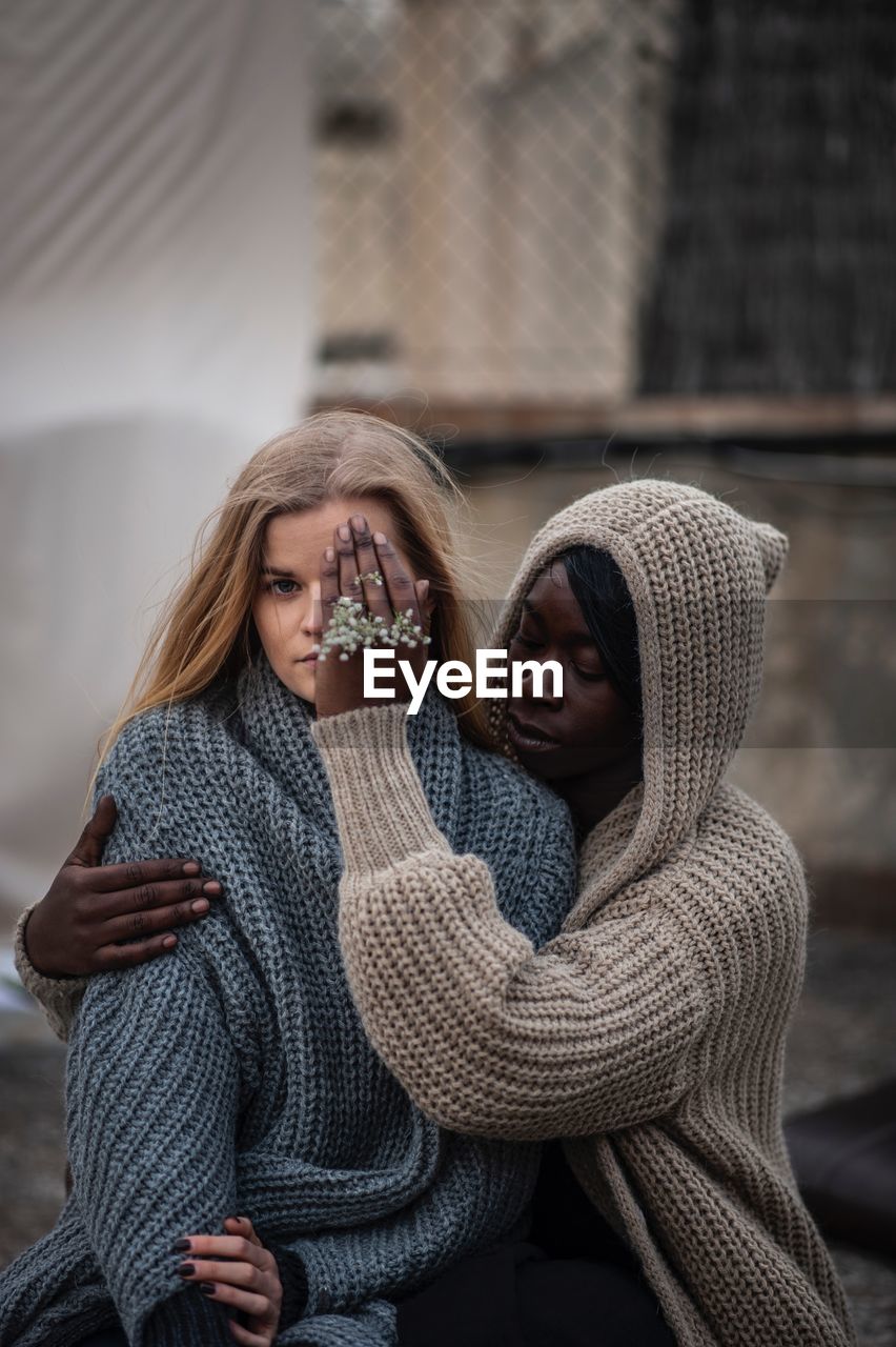 Woman covering friend eye in city