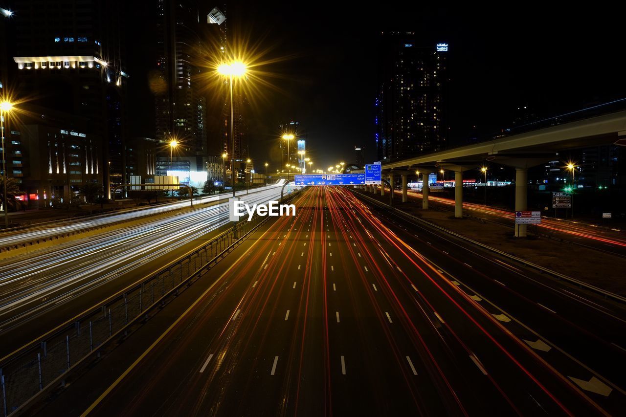 Light trails over illuminated street at night in city