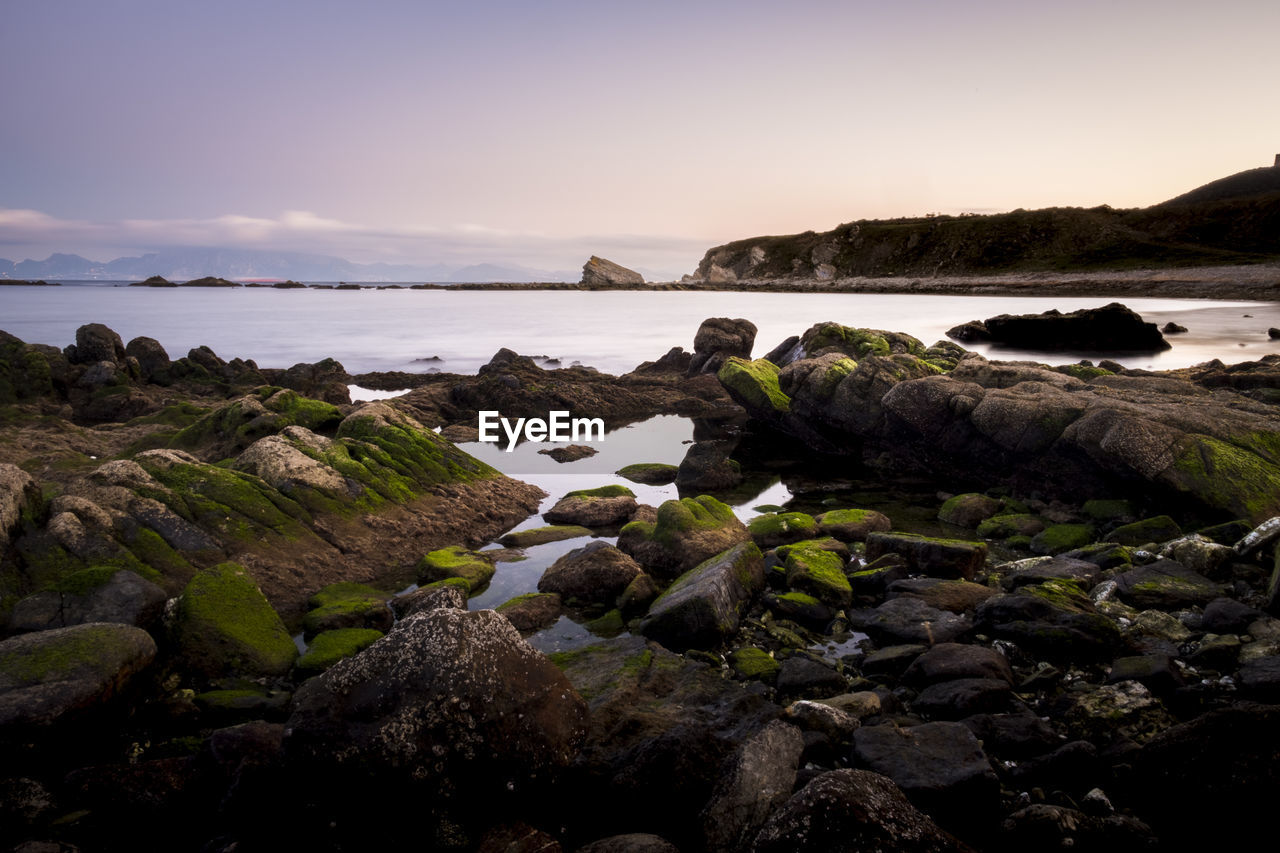 Rocks on beach against sky