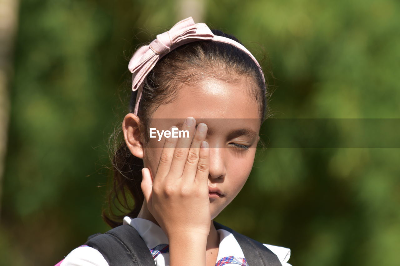Cute girl closing eyes outdoors
