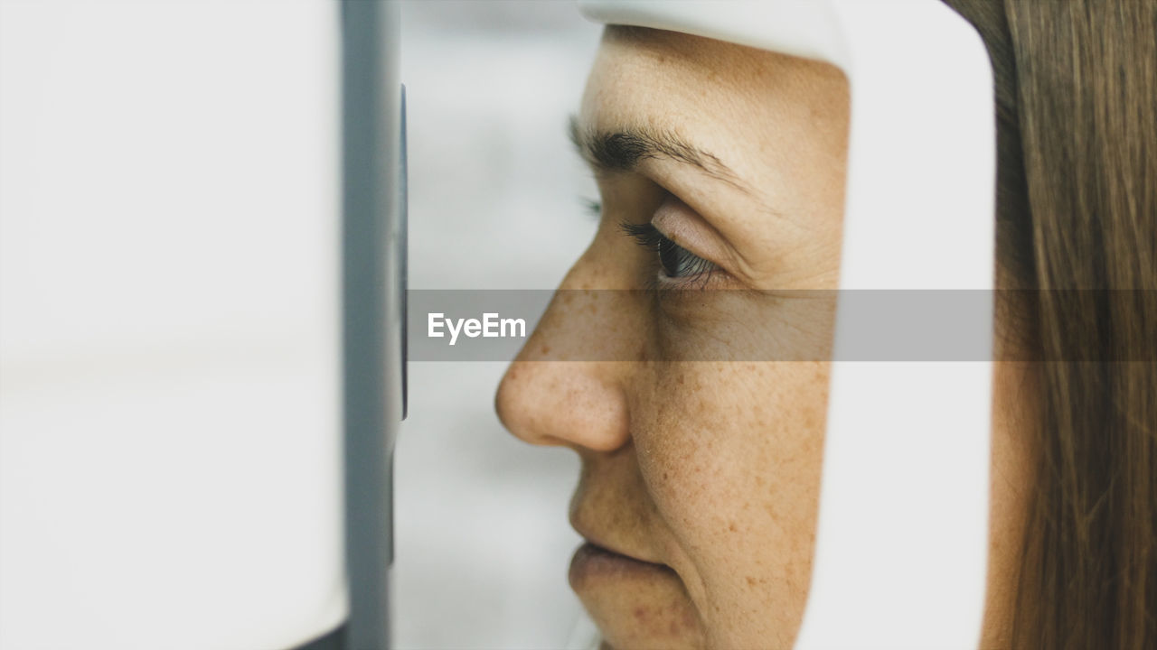 Close-up of woman looking through medical equipment