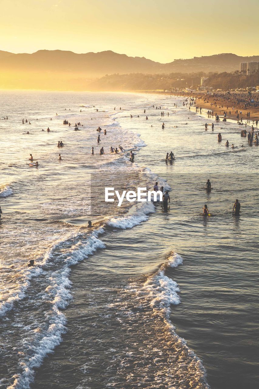 People at beach during sunset