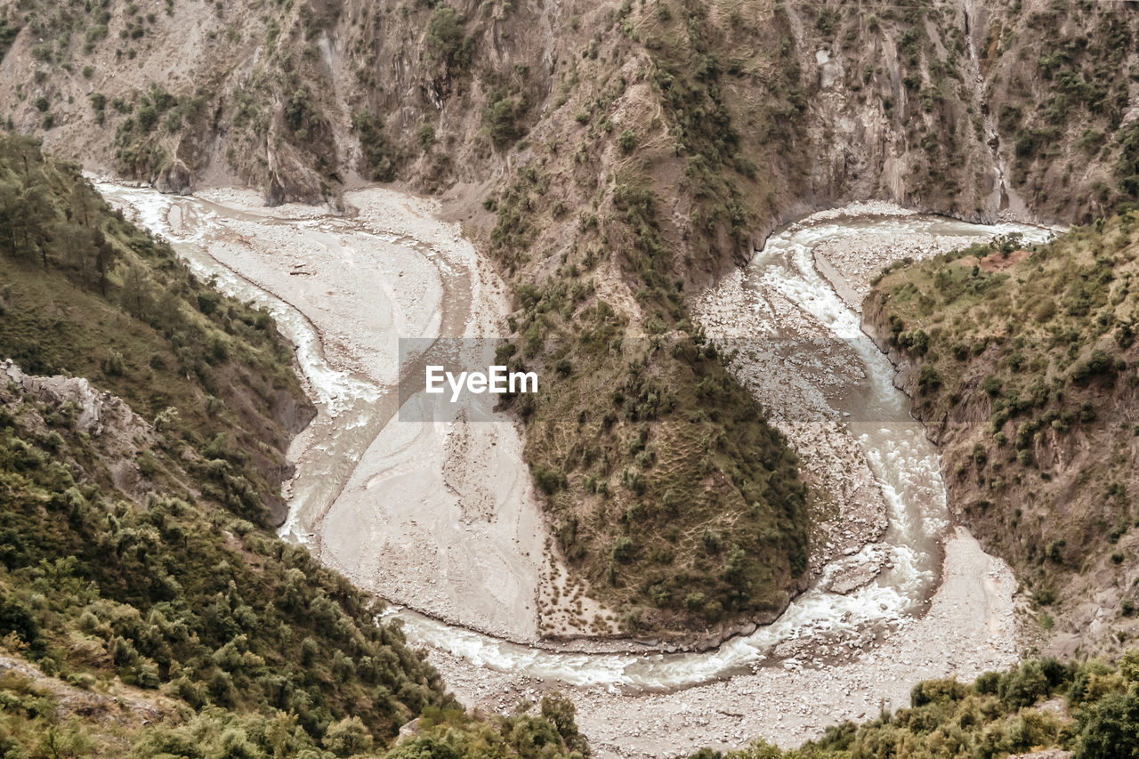Aerial view of river flowing through mountains