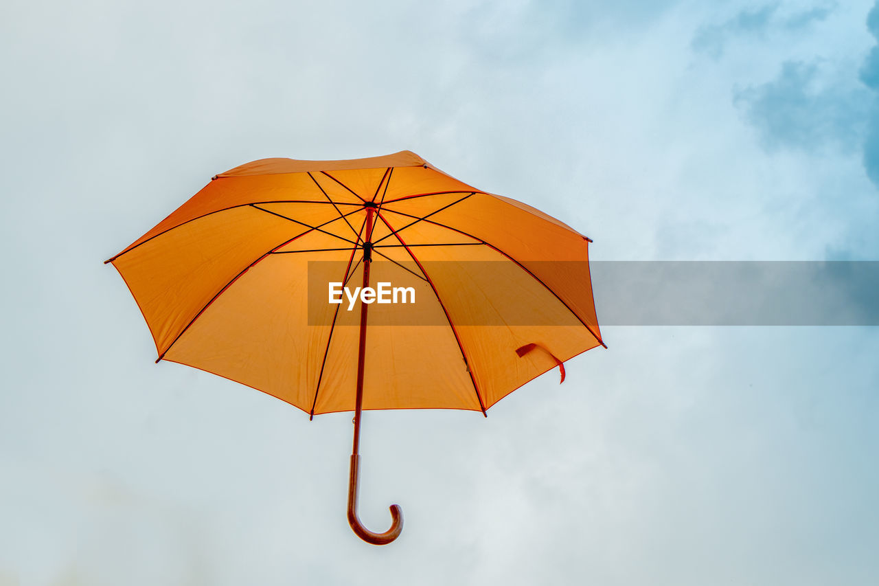 LOW ANGLE VIEW OF UMBRELLA AGAINST SKY DURING RAINY SEASON
