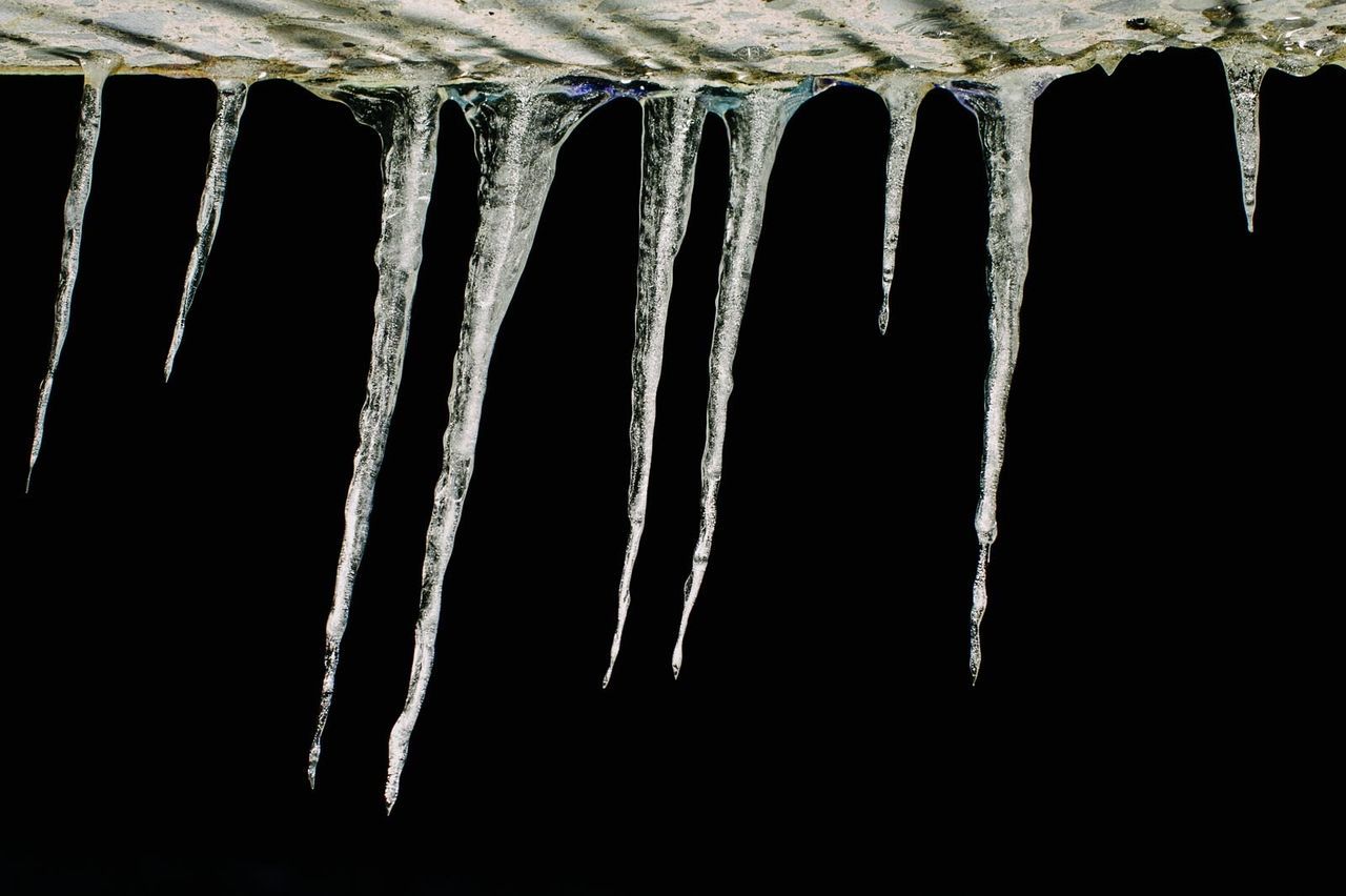 Close-up of icicles against black background