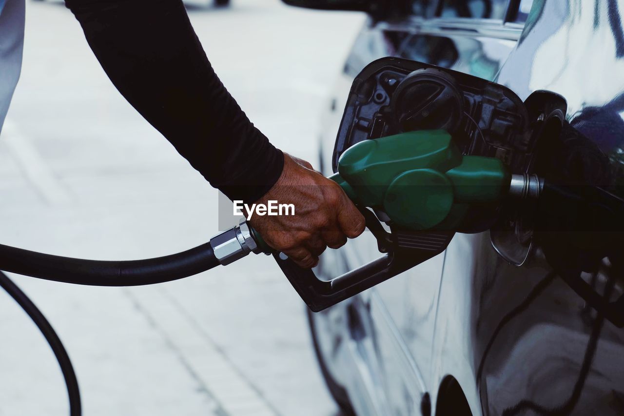 Cropped hand of man refueling car