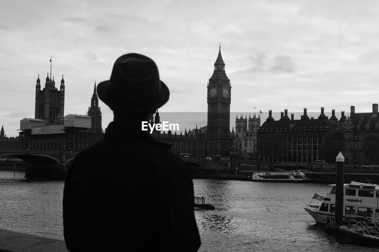 Rear view of man looking at big ben in city against sky