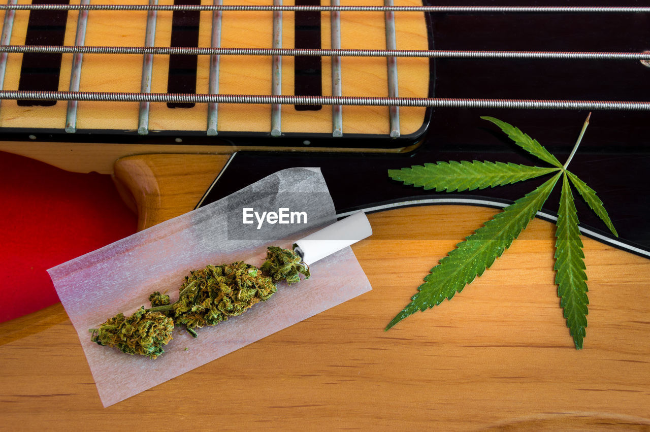 High angle view of marijuana and guitar on table