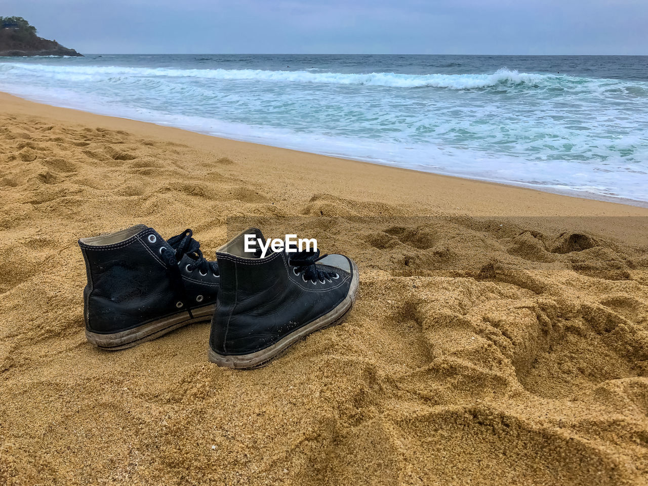HIGH ANGLE VIEW OF SHOES ON BEACH
