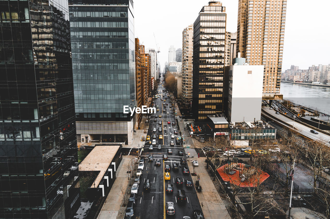 High angle view of vehicles on road along buildings