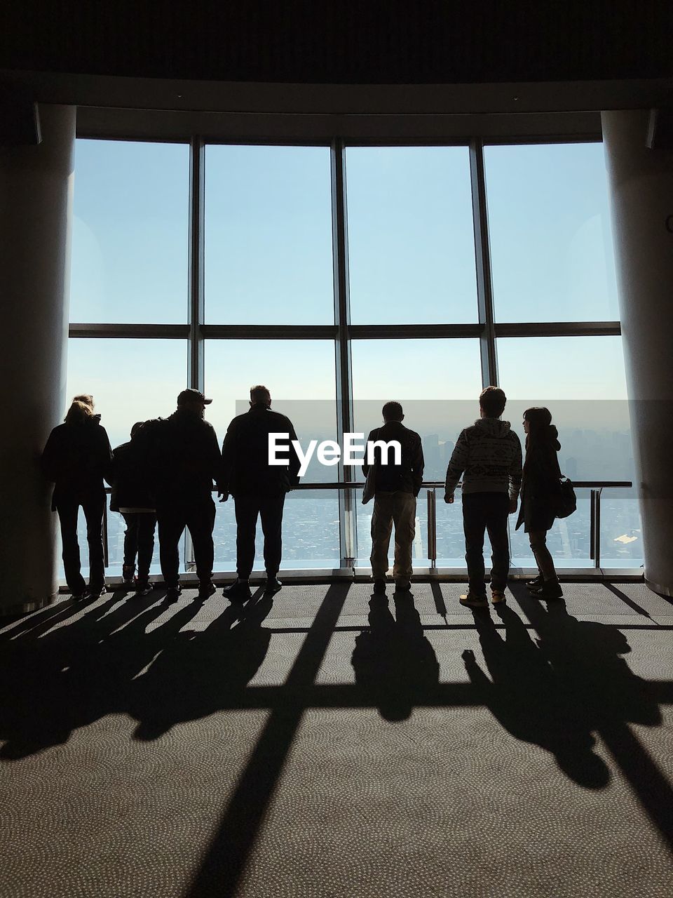 Silhouette people against window in building