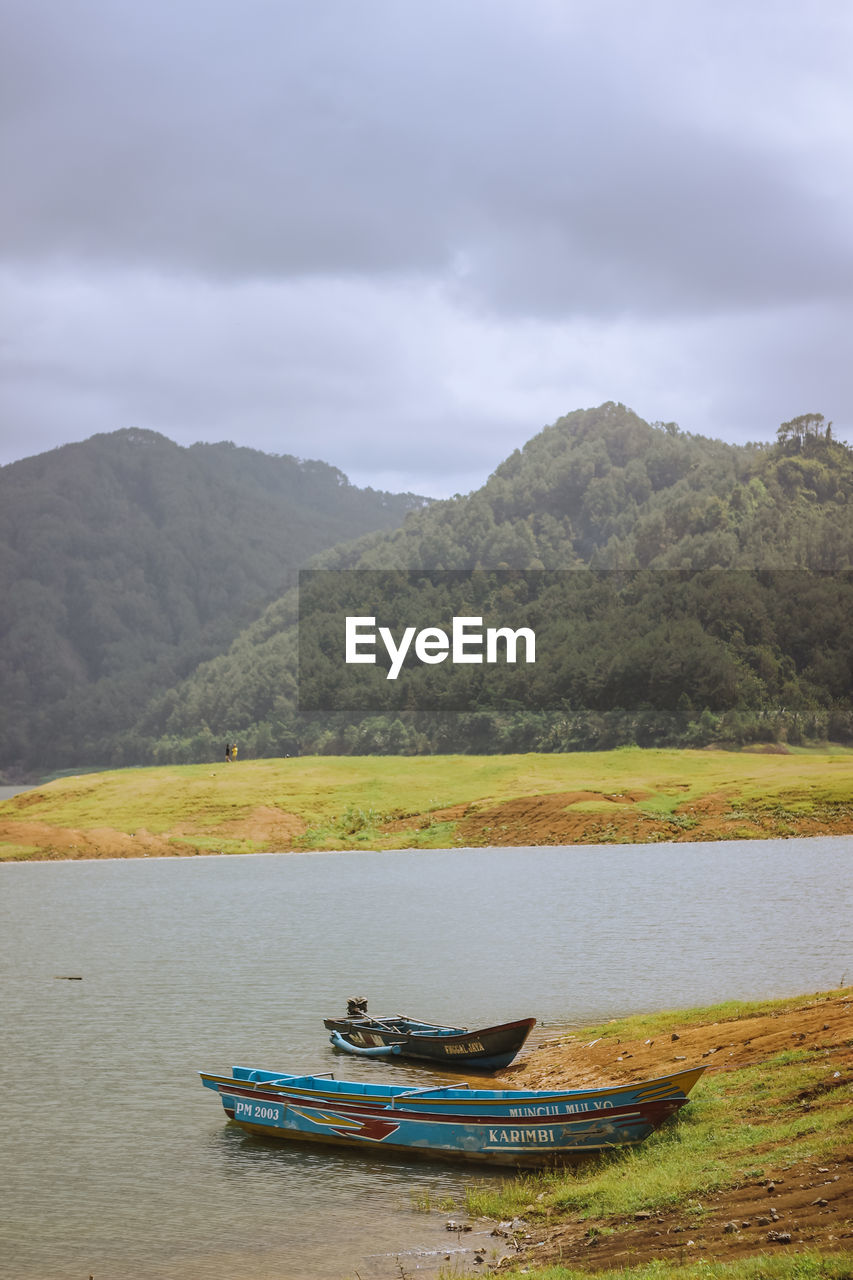 Scenic view of lake and mountains against sky.