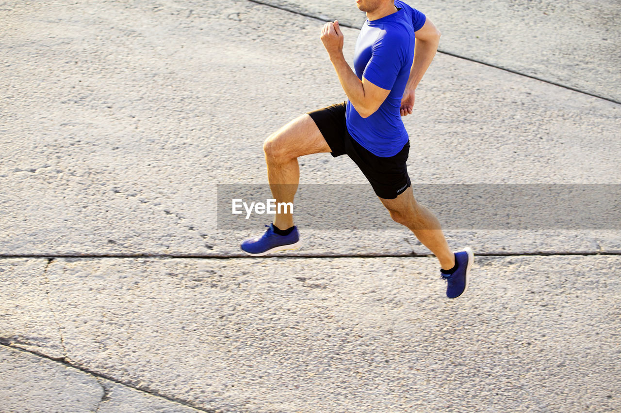 Side view of athlete exercising on road
