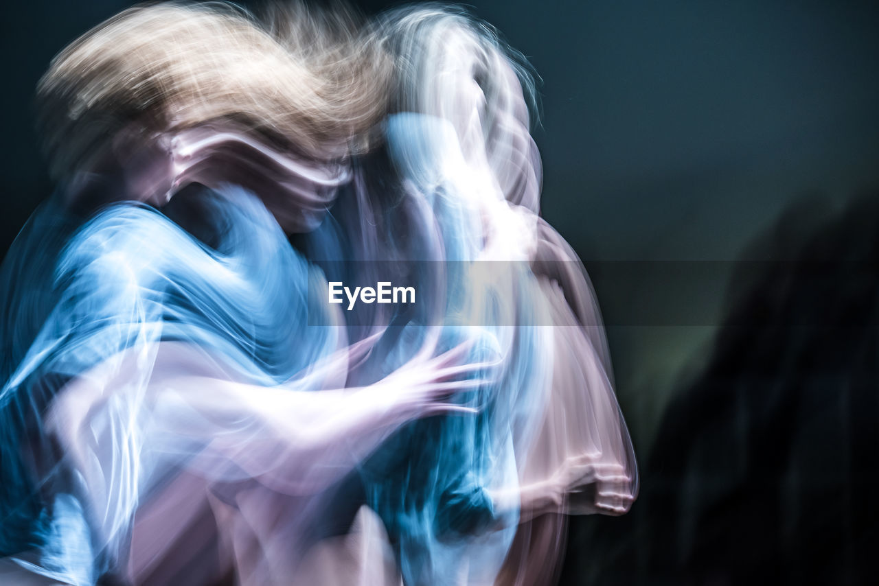 Blurred motion of dancer dancing against black background