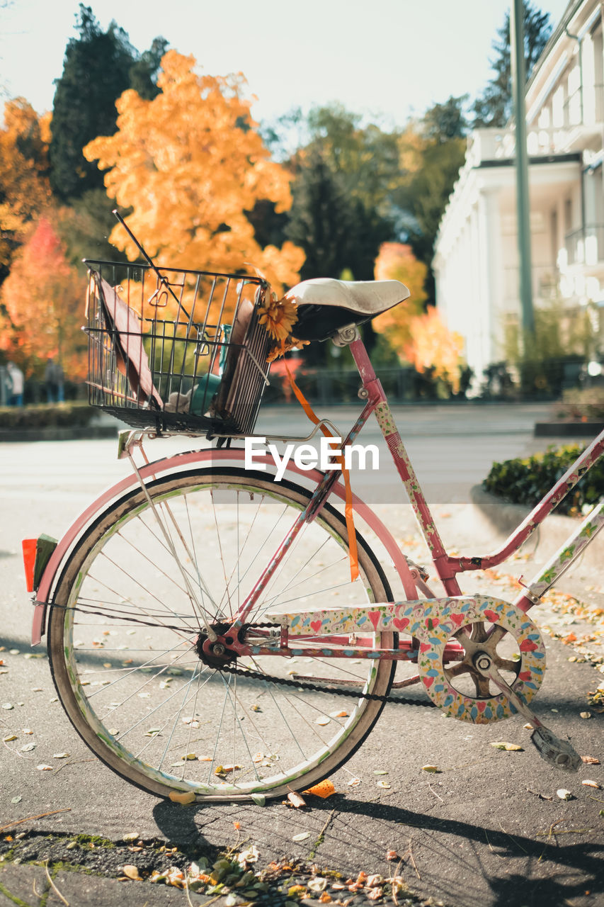 Bicycle with flat wheel and painted with hearts in the city on a sunny autumn day.