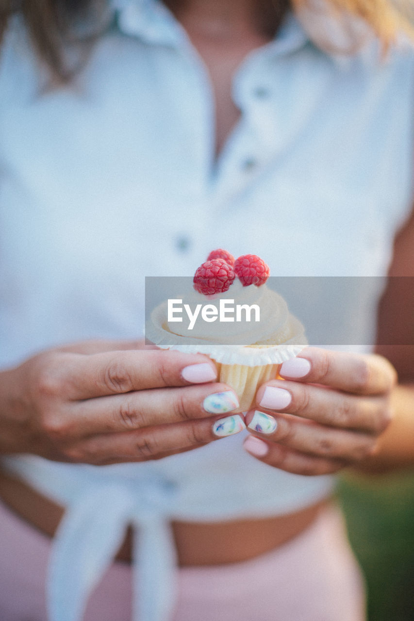 Female woman holding cupcake with strawberries in hands