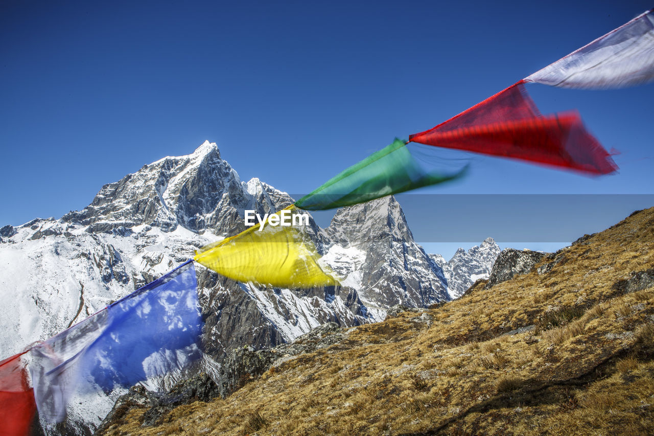 Prayer flags in the wind along the trail to everest base camp, nepal.