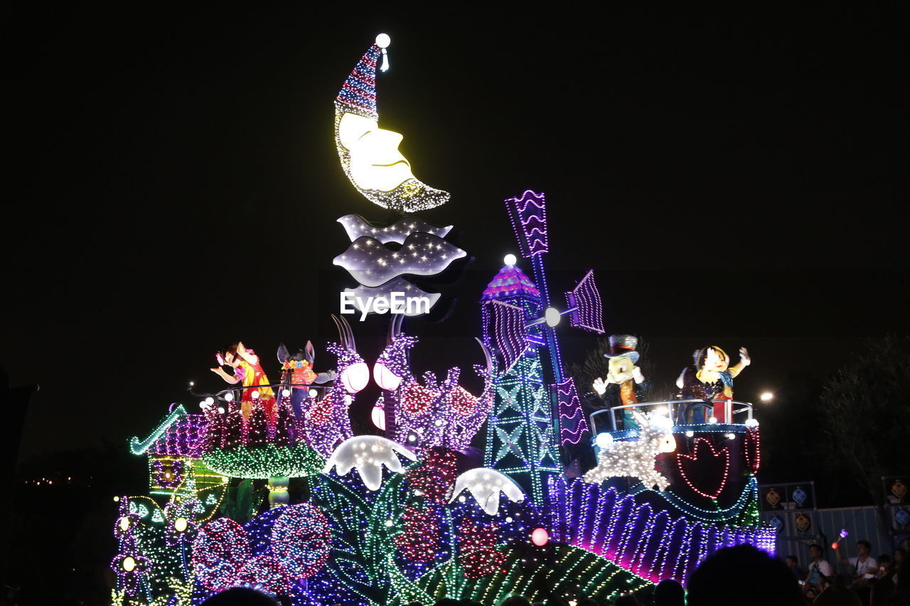 LOW ANGLE VIEW OF ILLUMINATED DECORATION AGAINST SKY AT NIGHT