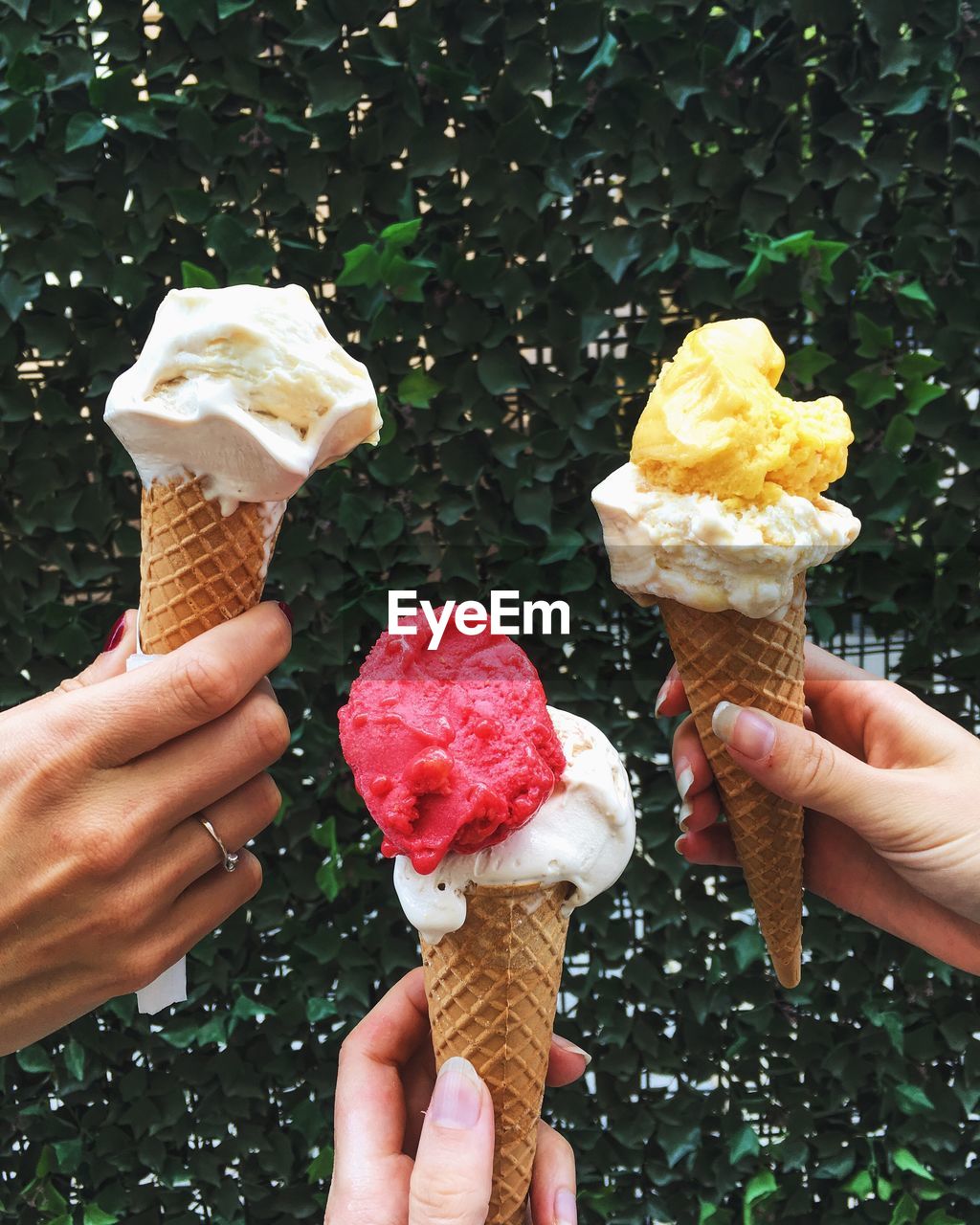 Human hands holding ice cream cones