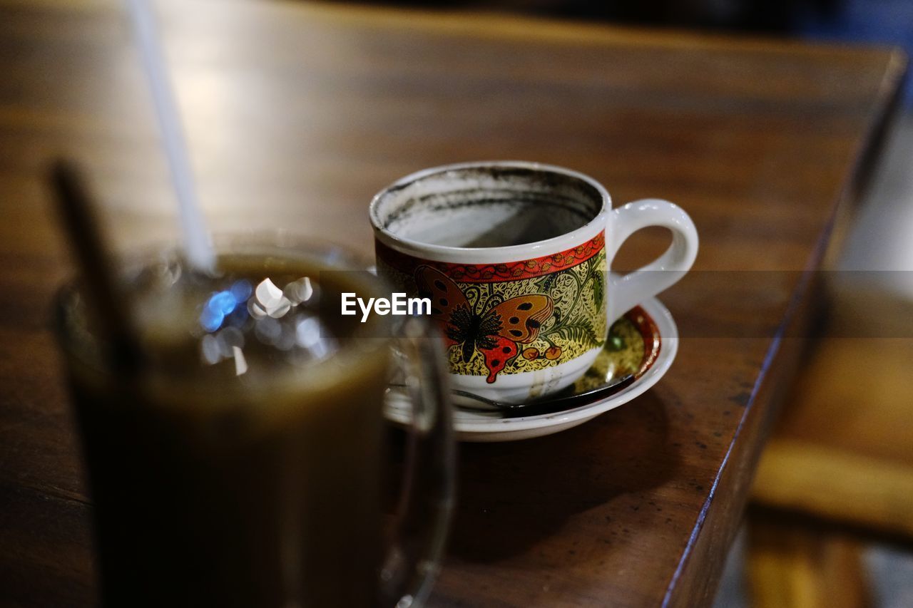 CLOSE-UP OF COFFEE CUP ON TABLE AT CAFE