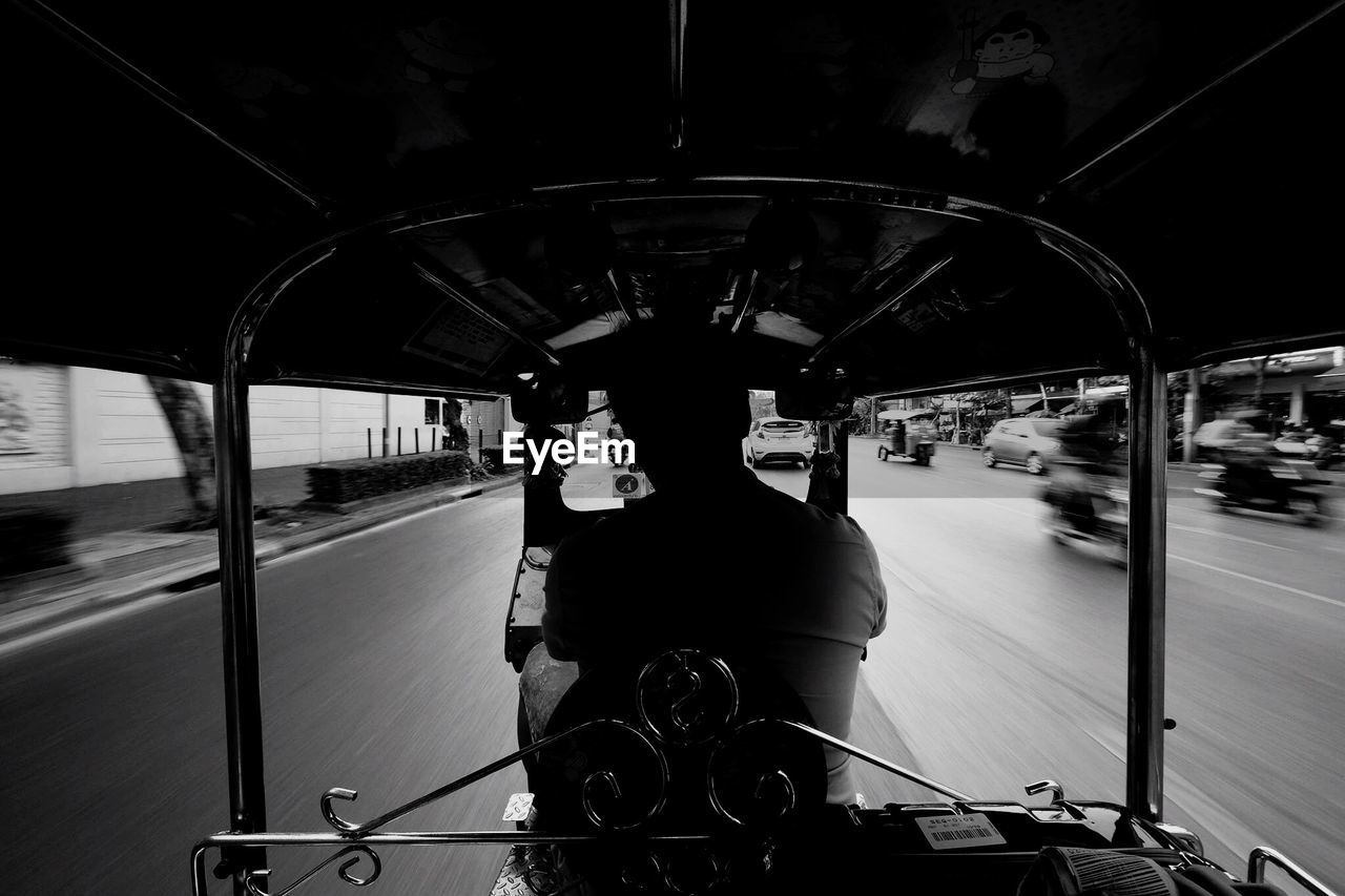 Rear view of man in tuktuk on street