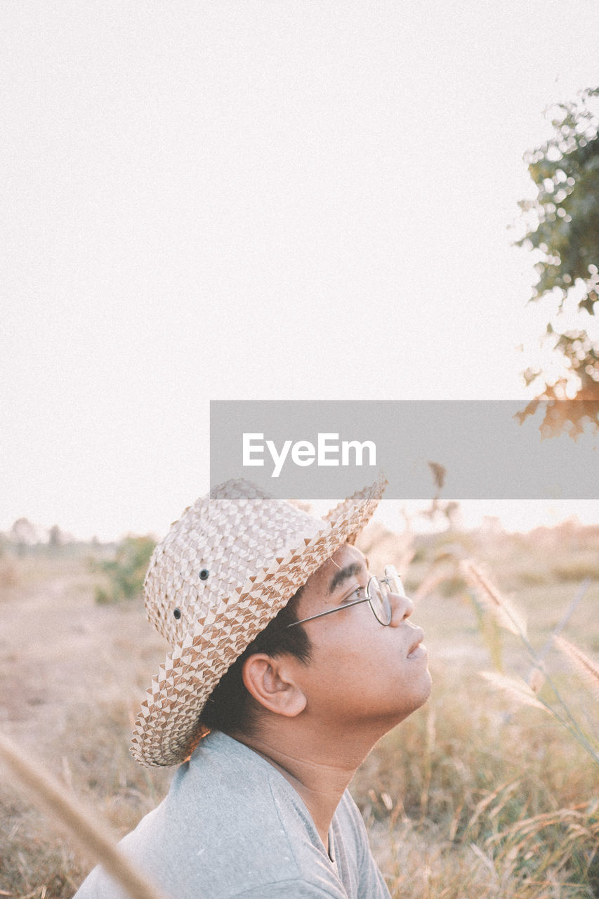 side view of woman looking away against clear sky