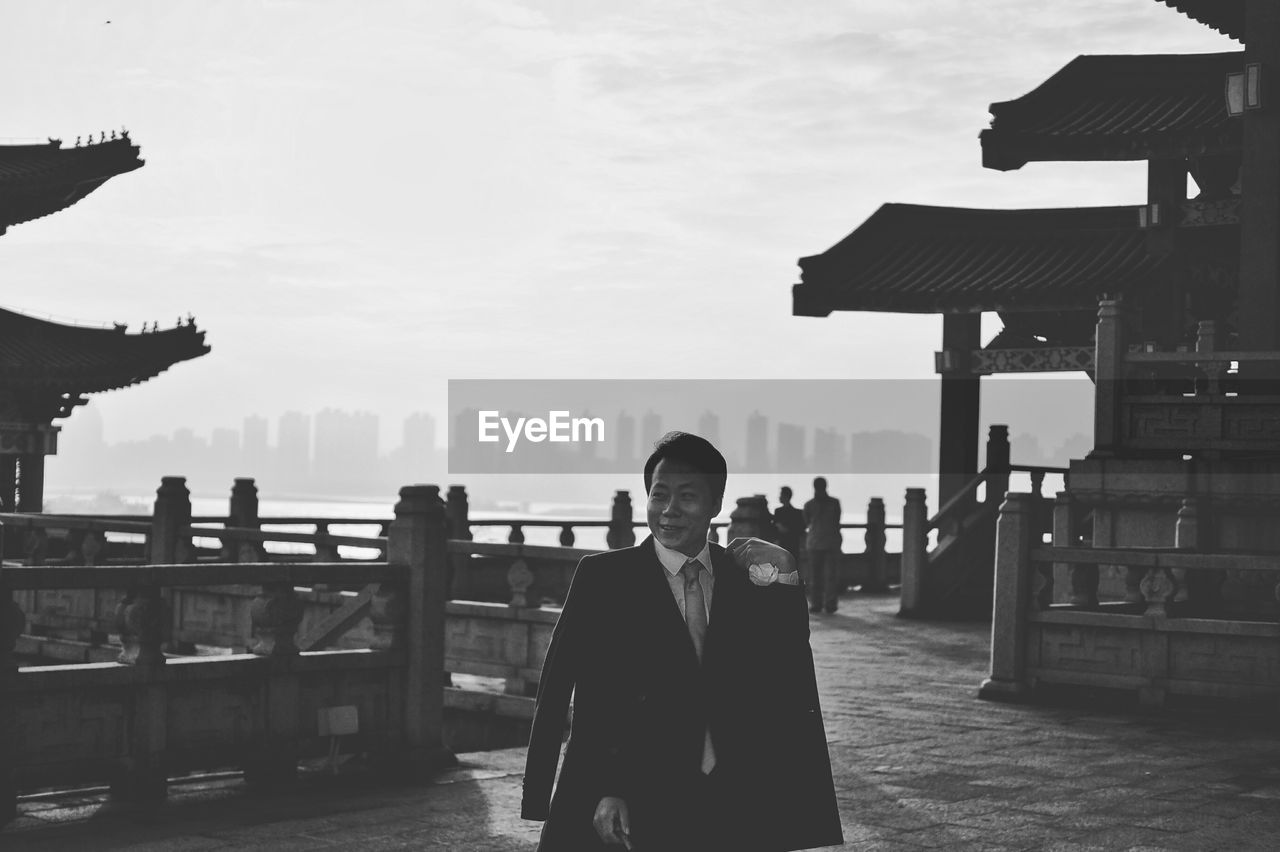 Businessman standing at pavilion of prince teng against sky
