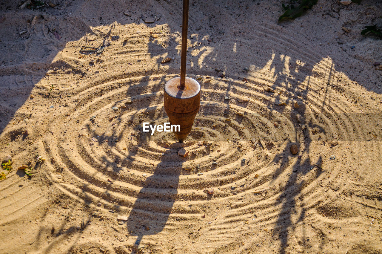 HIGH ANGLE VIEW OF CARVING ON SAND AT BEACH