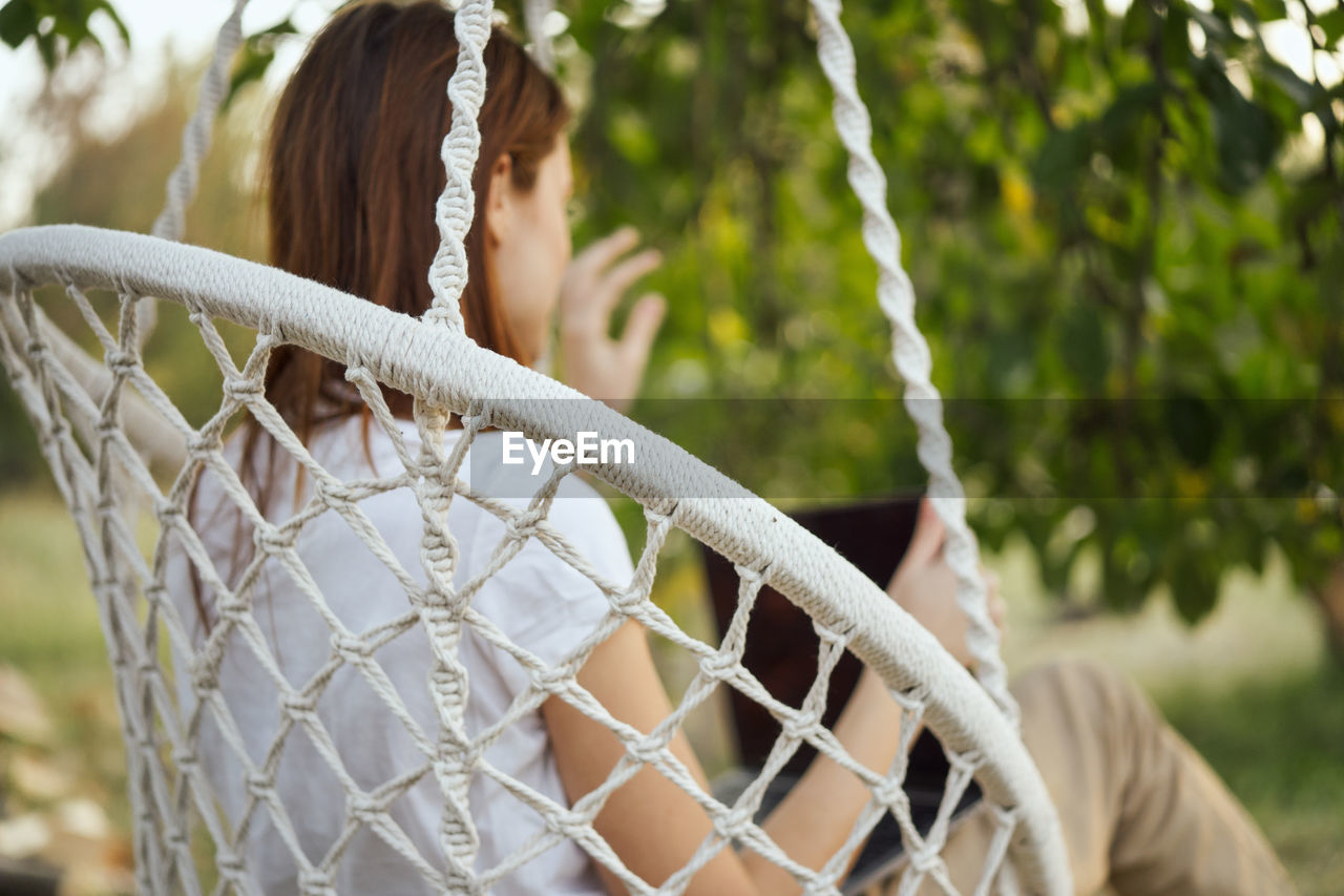 CLOSE-UP OF WOMAN LOOKING AT FENCE