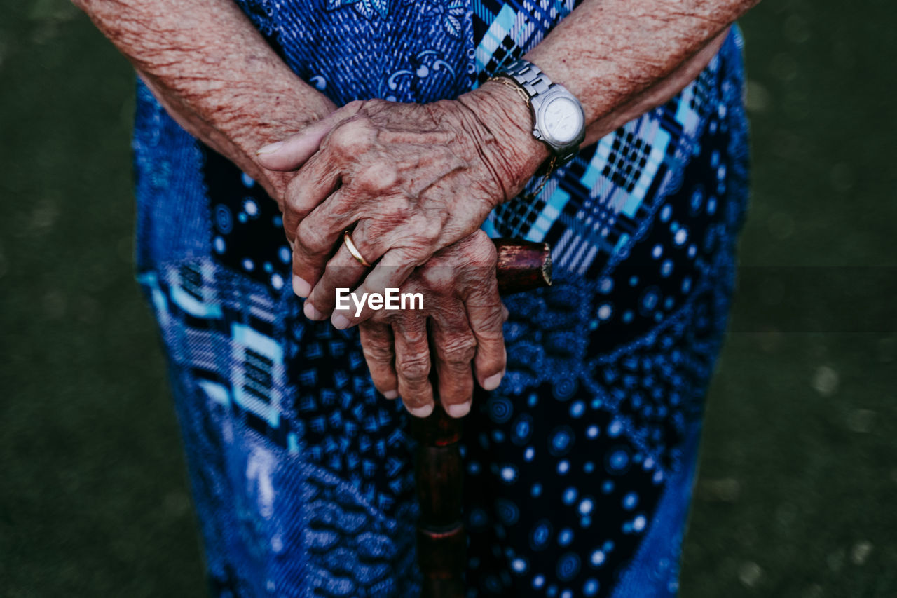 Midsection of senior woman holding walking cane