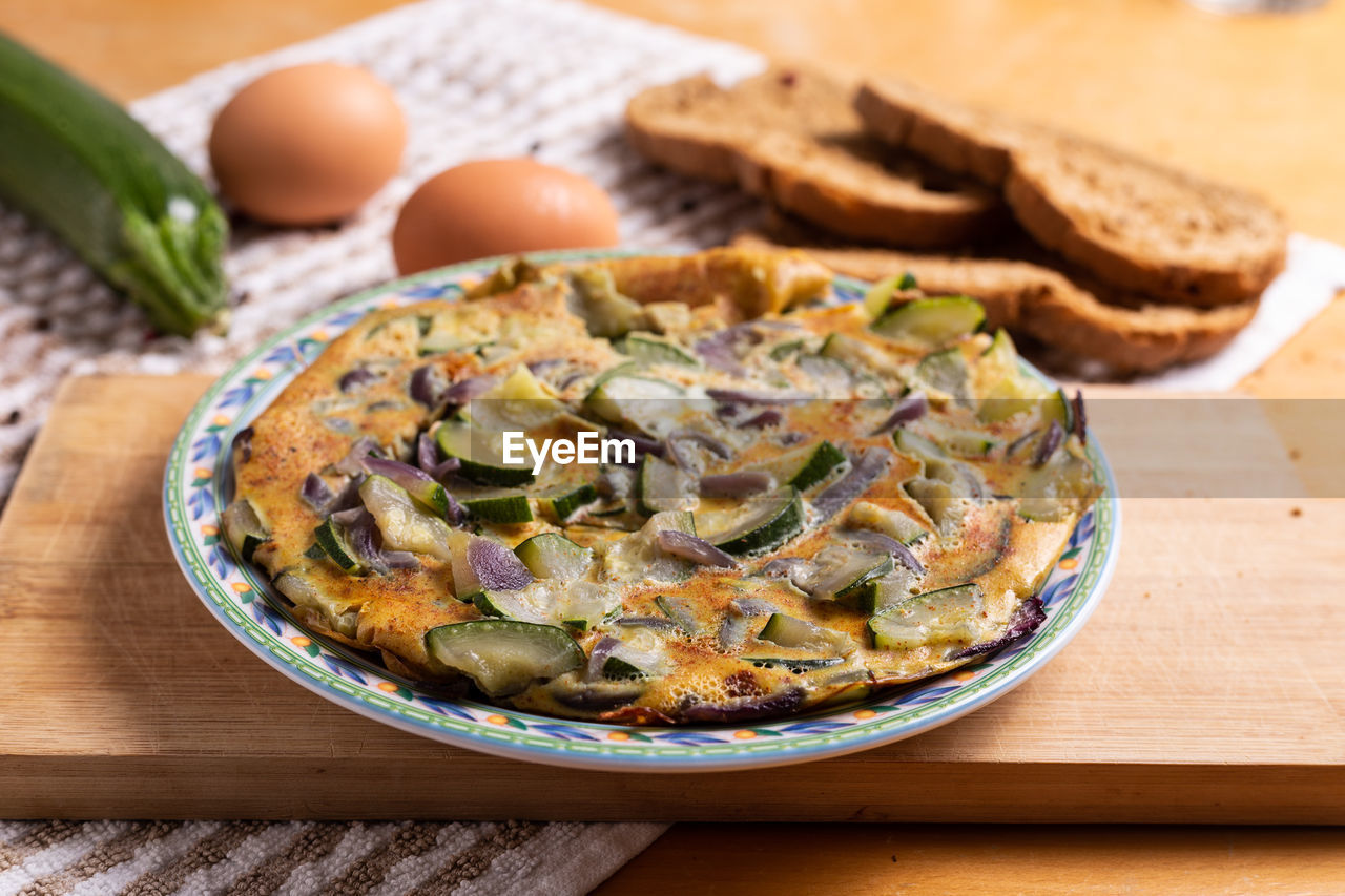 Zucchini and red onion omelette. high angle view of omelette on table