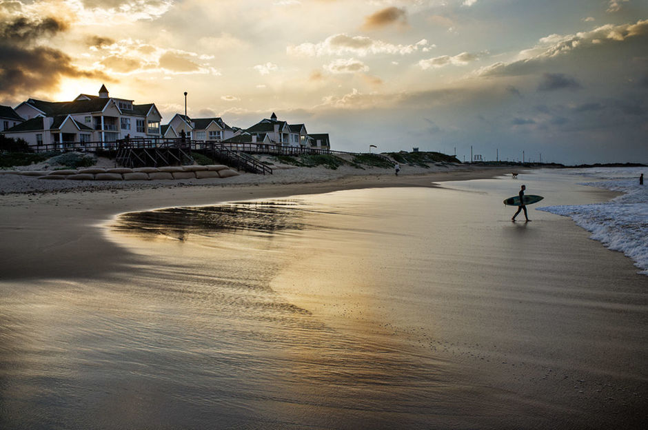 Man with surfboard walking on beach