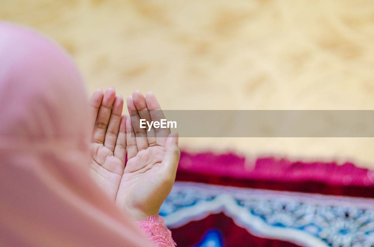 Cropped image of woman praying with hands cupped