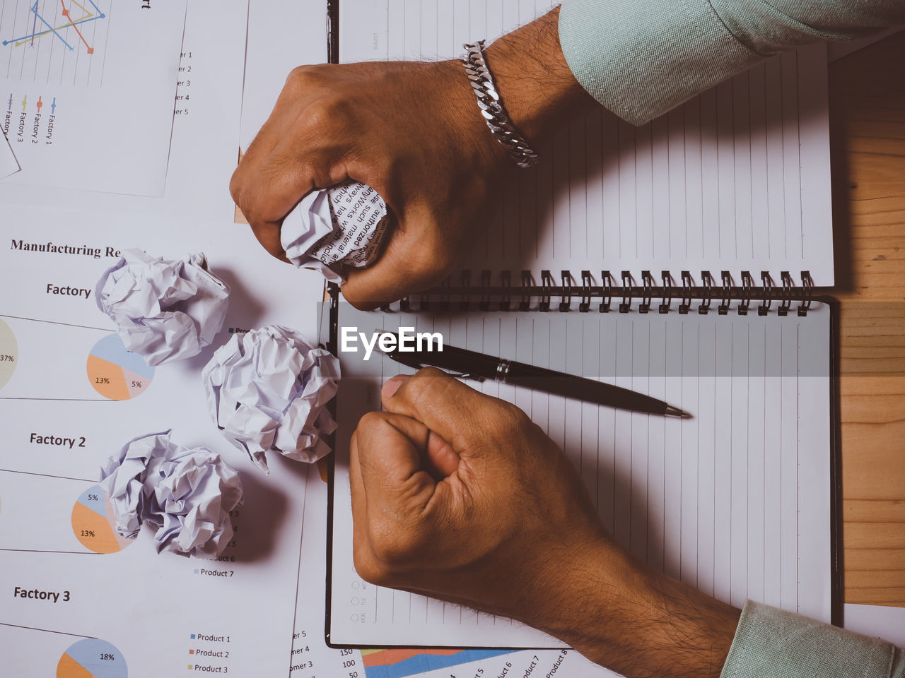 HIGH ANGLE VIEW OF MAN WORKING ON PAPER