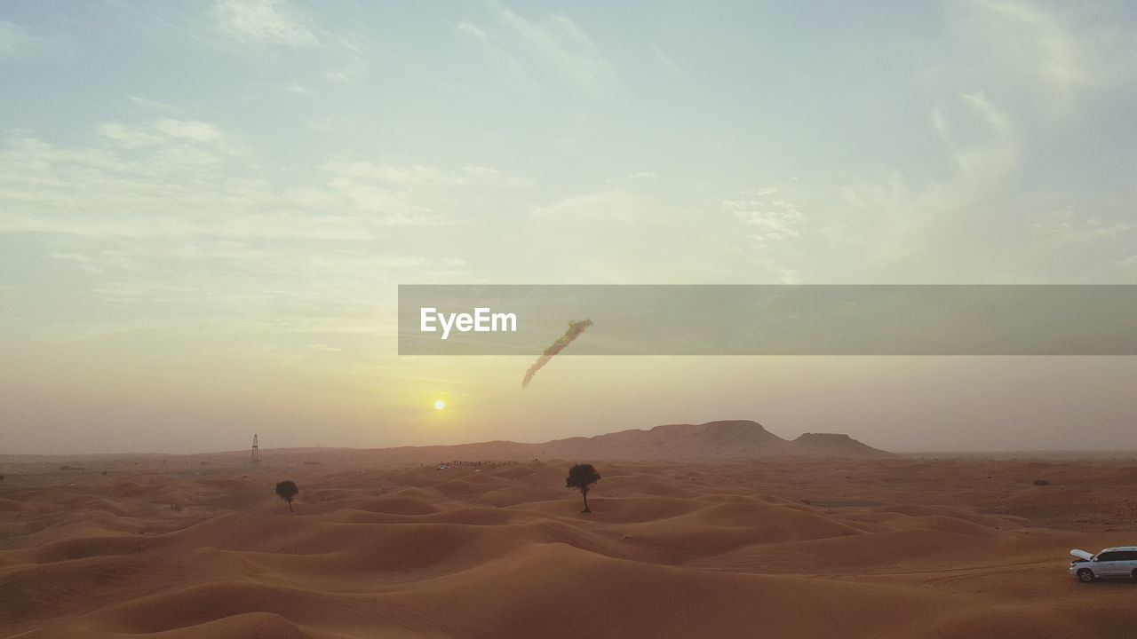 PEOPLE ON DESERT AGAINST SKY DURING SUNSET