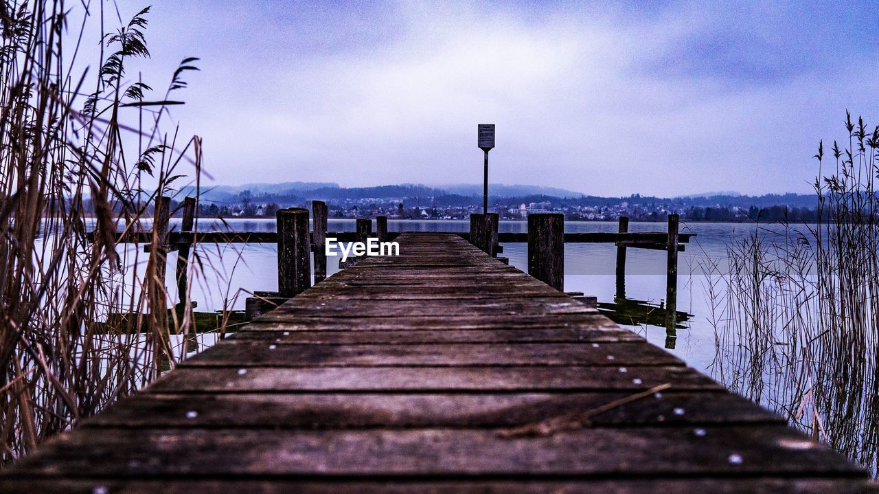 VIEW OF WOODEN PIER OVER LAKE