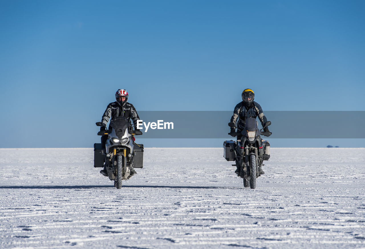 Two men riding touring motorbike's on the salt flats of uyuni