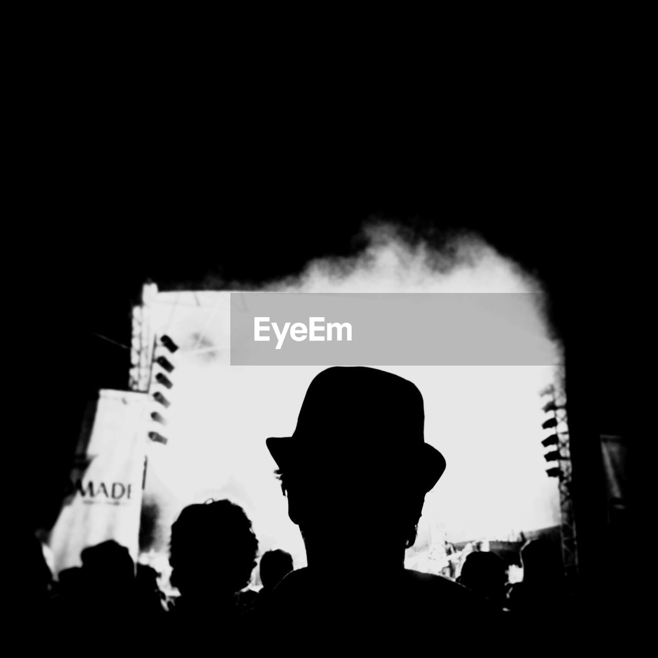 Silhouette of man in hat at concert