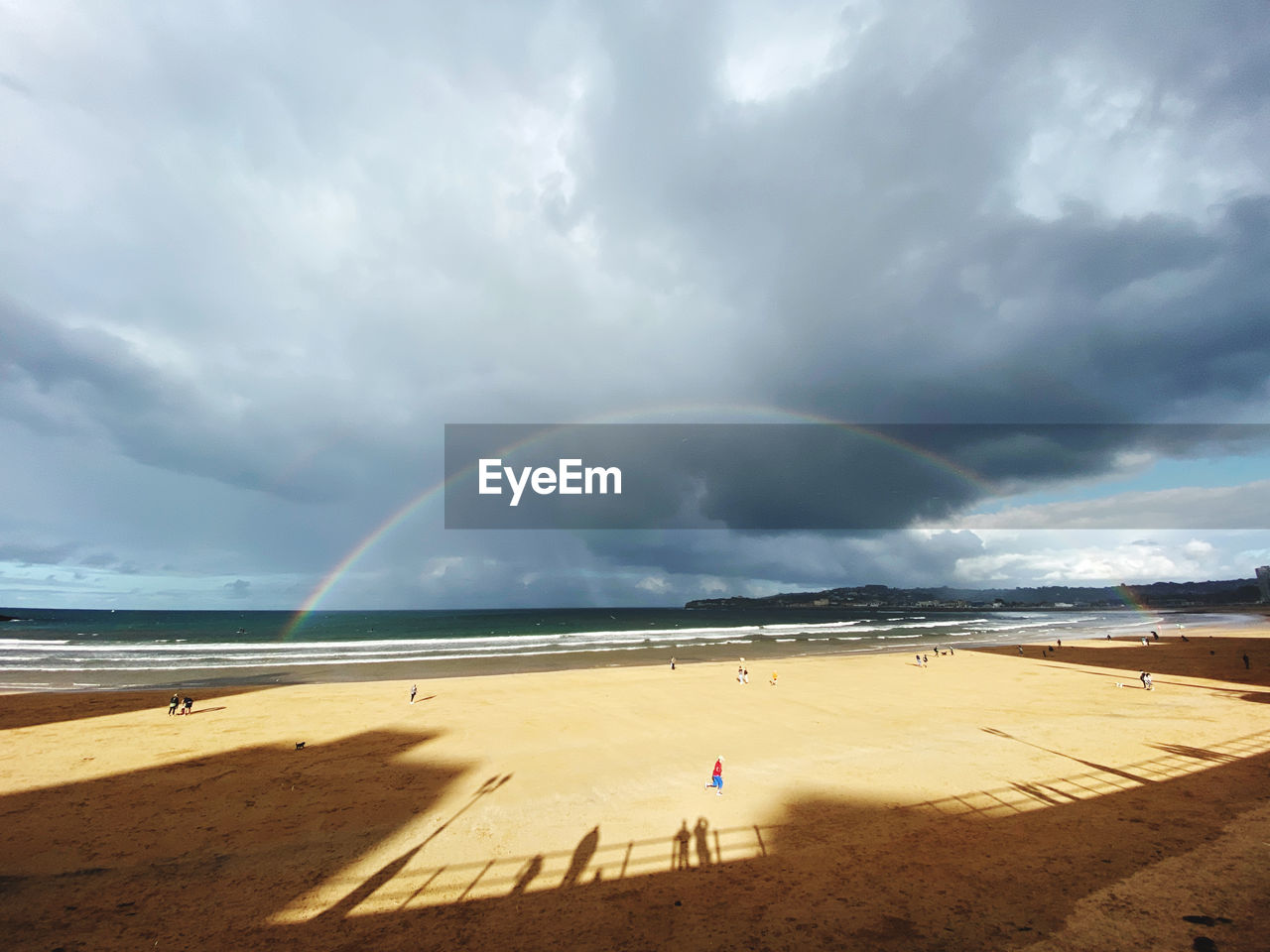 Scenic view of beach against sky, and rainbow