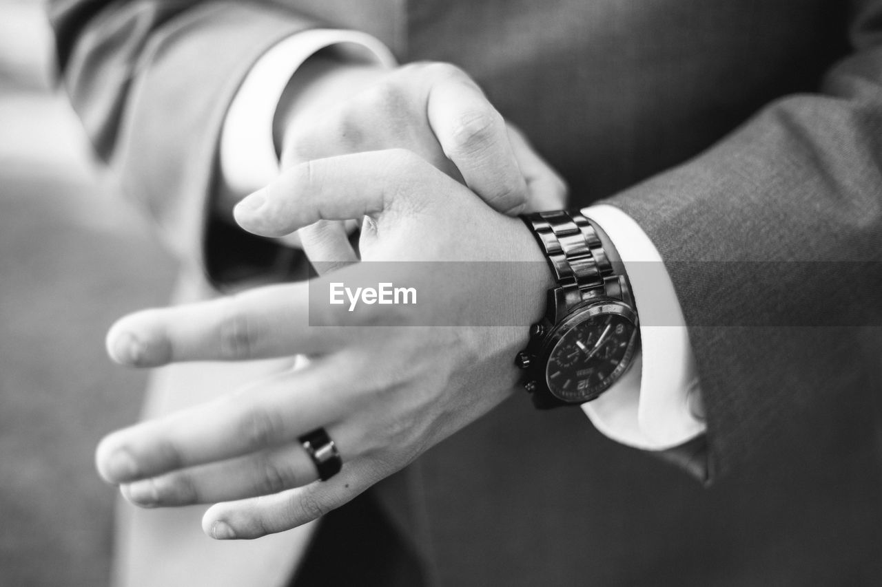 Midsection of groom wearing wristwatch