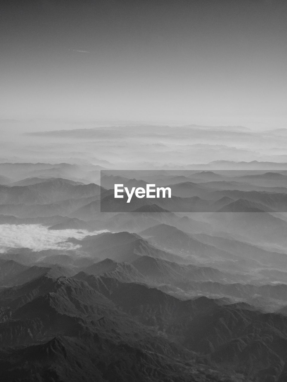 Aerial view of mountains against clear sky in foggy weather