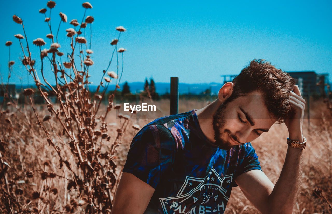 Young man looking away on field
