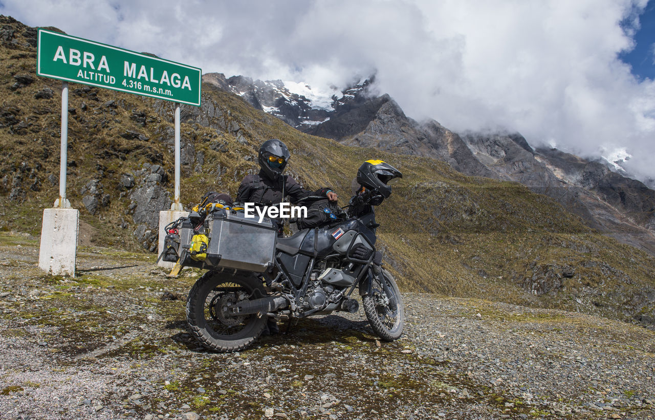 Woman standing by her motorbike at abra de malaga pass (4316 m.s.n.m.)