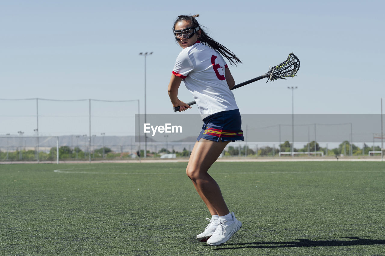 Player with lacrosse stick playing on sports field