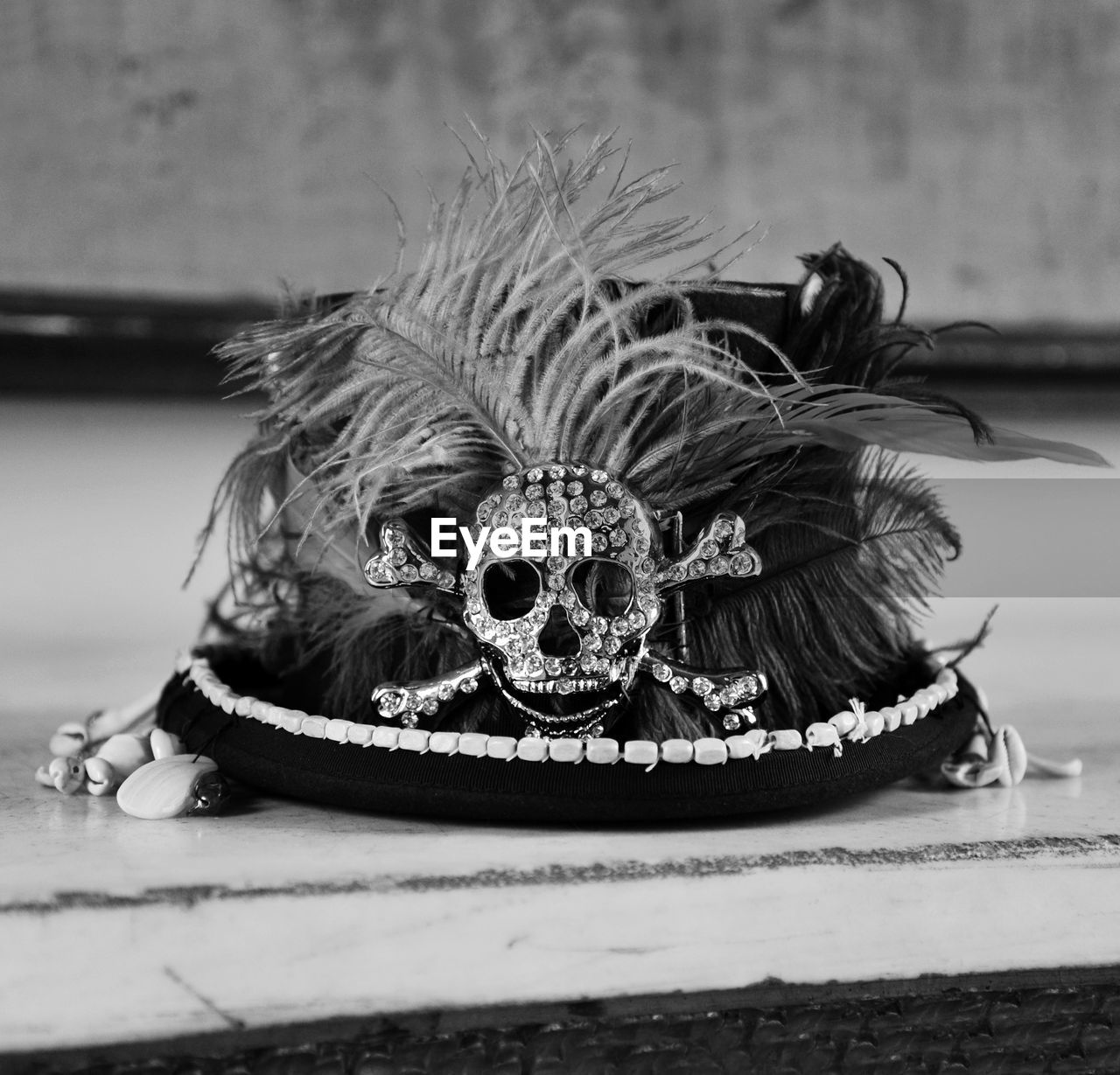 Close-up of hat with feathers and decorative skull on table